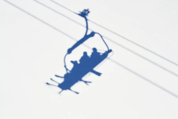 Ombre di sciatori in seggiovia d'inverno, sopra una pista da sci nel comprensorio sciistico di Serre Chevalier, Francia, in una giornata di sole . — Foto Stock