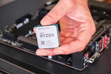 Moherboard 'un üzerinde bir Amd Ryzen 3700x Cpu tutan bir erkek el, özel bilgisayar yapımının bir parçası..