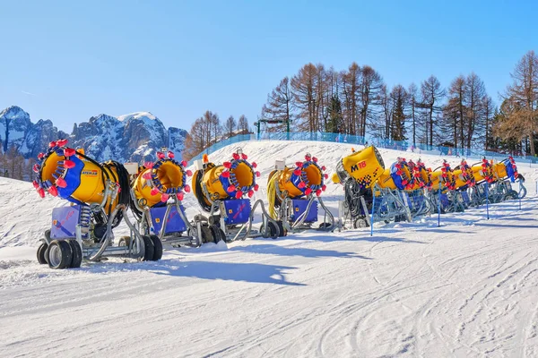 Row of idle snow guns (cannons) branded Latemar, from TechnoAlpin, lined up on a ski slope in Val di Fassa domain, Dolomites, Italy, on a bright sunny day. — Stock Photo, Image