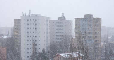 Romanya 'nın Bükreş kentindeki yüksek apartmanlara karşı şiddetli rüzgarlı kar fırtınası yanlamasına kar taneleri esiyor.