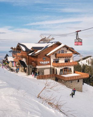Yager Chalet dağ kulübesi, Ocak 2020 'de Postavarul Dağı' ndaki Brasov kayak merkezinde açıldı. Üzerinde kırmızı bir teleferik olan gün batımı manzarası..