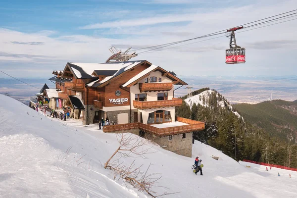 Yager Chalet dağ kulübesi, Ocak 2020 'de, Postavarul Massif' te Brasov kayak merkezinde yeni açıldı. Üzerinde kırmızı bir teleferik olan gün batımı manzarası..