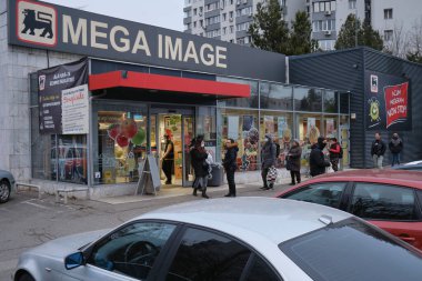 Bükreş, Romanya - 24 Mart 2020: İnsanlar daha katı Coronavirus tecrit tedbirleri duyurulduktan sonra Mega Image süpermarketinin önünde kuyrukta bekleyip aralarında güvenli bir mesafe bırakıyorlar.