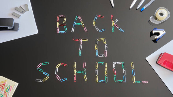 Back to School concept - flat lay composition. Paperclips forming the words on black reflexive table, surrounded by sheets of paper and school related objects.