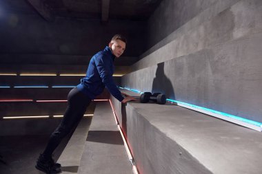 Adam neon ışıklarının arka planında eğitim görüyor.