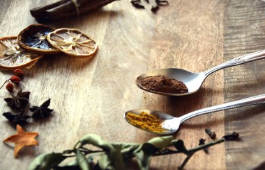 Spices on a wooden table in spoons. Photo image.