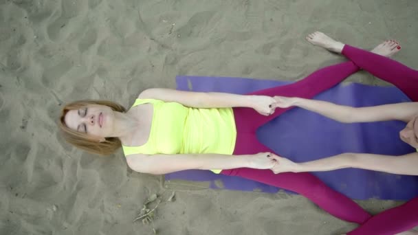 Mulheres fazendo exercícios de alongamento na areia — Vídeo de Stock