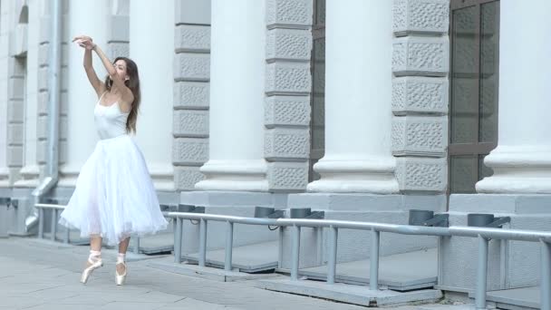 Женщина-балерина танцует возле светлого здания — стоковое видео
