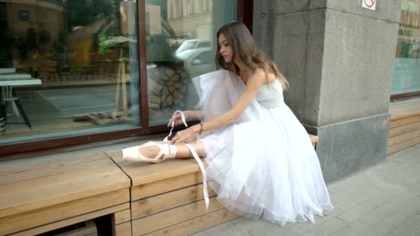 Балерина надевает пуанты на ноги — стоковое видео