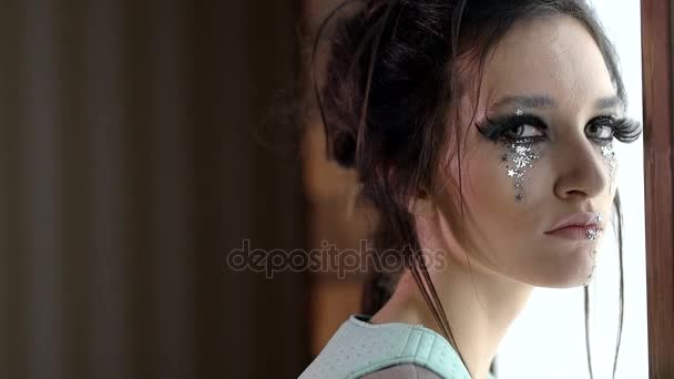 Vacker flicka modell ansikte med glitter på hennes ansikte och mode makeup — Stockvideo