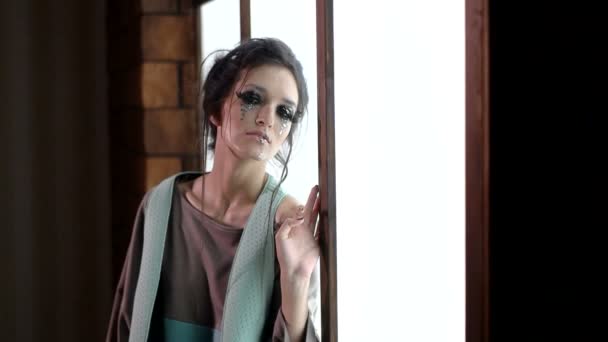 패션 소녀는 창 고는 카메라를 보고 근처 서 — 비디오