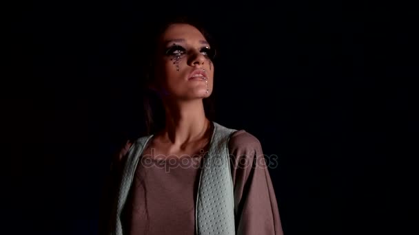 Femme à la mode avec maquillage dans un endroit sombre 