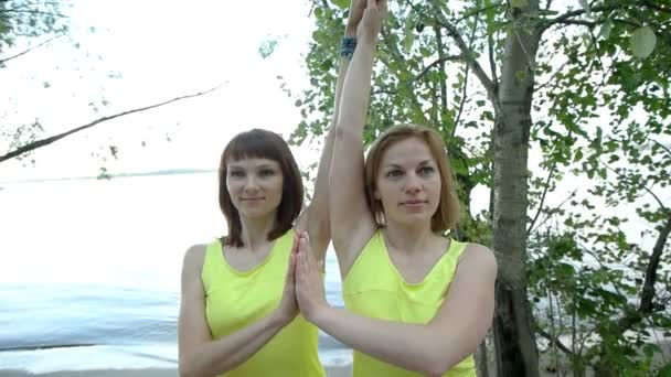 Jovens mulheres fazendo ioga na praia — Vídeo de Stock