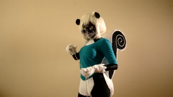 Woman dressed in a skunk costume is standing near the wall with a computer mouse — Stock Video