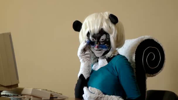 Woman dressed in a skunk costume shows her emotions sitting at the computer — Stock Video