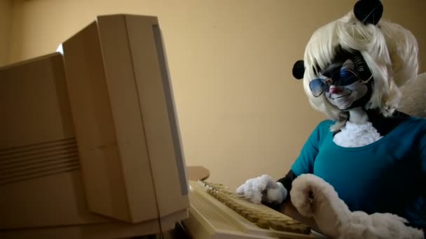 Woman dressed as a skunk sits at a table and typing on the keyboard — Stock Video