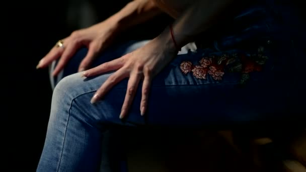 Γυναίκα κάθεται στον πάγκο και εγκεφαλικά επεισόδια στα πόδια της από τα χέρια της — Αρχείο Βίντεο