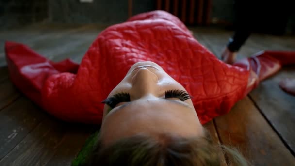 Модная женщина лежит на полу, вокруг нее ходят женские ноги — стоковое видео