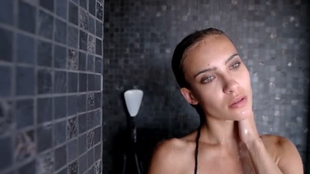 Female in a bathing suit takes a shower — Stockvideo