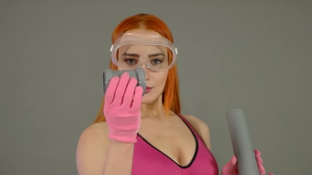Pembe eldiven inşaat plastik bir boru ile bir kız — Stok video