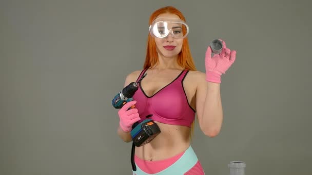 Женщина-строитель в сексуальной одежде держит в руках инструмент — стоковое видео
