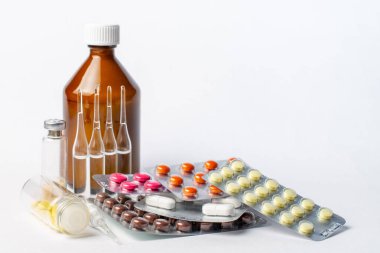 Beyaz arka planda kabarcıklar, şişeler, ampuller ve kavanozlardaki farklı ilaçlar