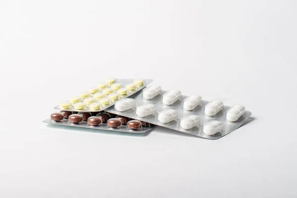 Una pila di vesciche con pillole di colore su uno sfondo bianco — Foto Stock