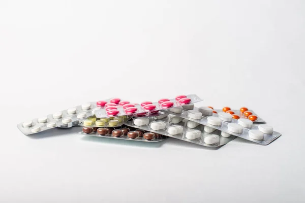 Uma pilha de bolhas com pílulas de cor em um fundo branco — Fotografia de Stock