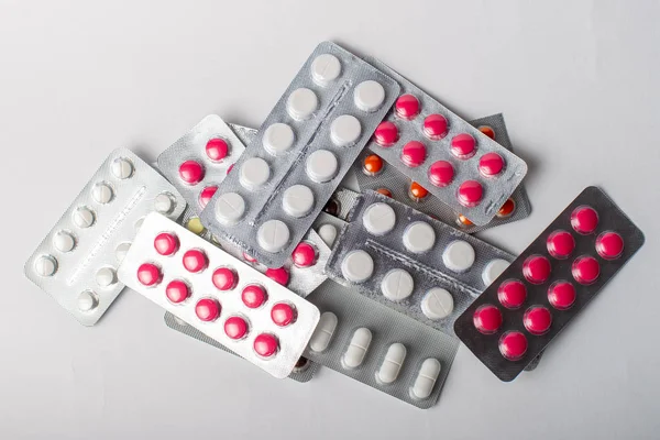 Una pila di vesciche con pillole di colore su uno sfondo bianco. Posa piatta, vista dall'alto . — Foto Stock