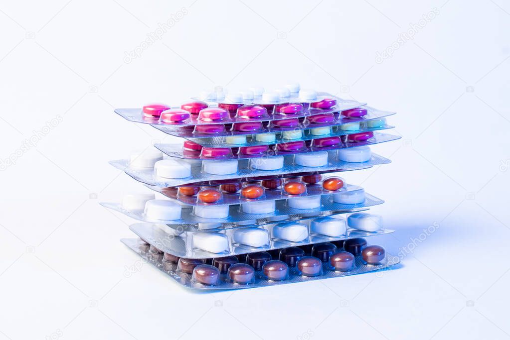 a stack of blisters with color pills on a white background. Blue light
