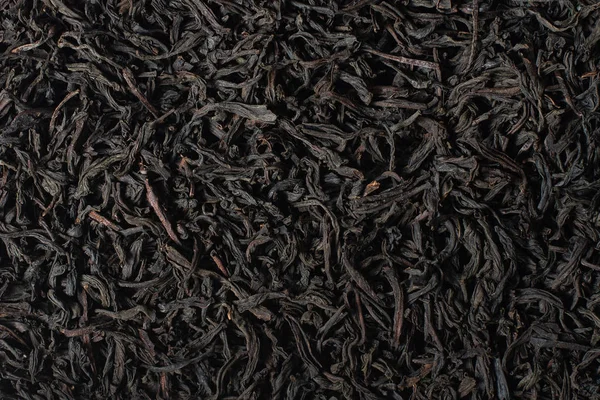 Thé noir aux feuilles. Grandes feuilles de fond de thé noir, gros plan . — Photo