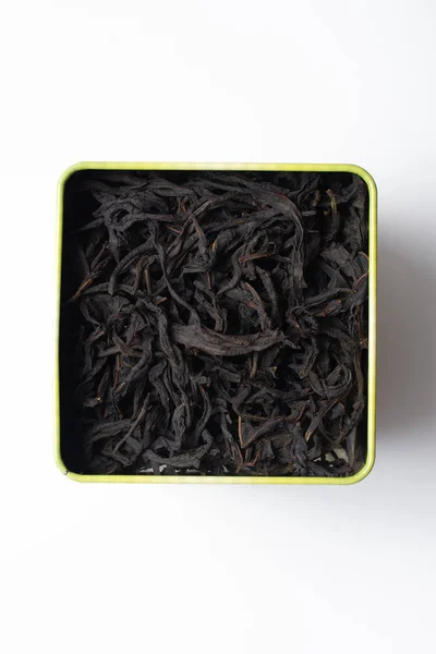 Grandes feuilles de thé de saule fermenté dans une boîte carrée. Isoler sur fond blanc . — Photo