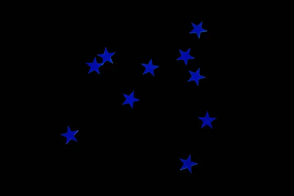 Flitterek szórása kék csillagok formájában, elkülönítve fekete alapon — Stock Fotó