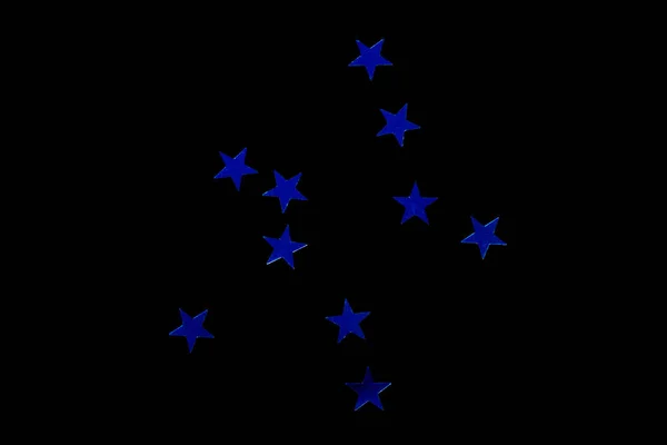 Flitterek szórása kék csillagok formájában, elkülönítve fekete alapon — Stock Fotó