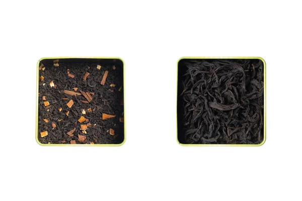 Ξηρά φύλλα μαύρου τσαγιού φρούτων με κανέλα και πορτοκάλι και καθαρό μαύρο τσάι σε δύο τετράγωνες κονσέρβες. Απομόνωση σε λευκό φόντο. — Φωτογραφία Αρχείου