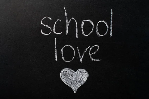 La inscripción "amor escolar" en una pizarra negra con tiza blanca. Imagen del corazón — Foto de Stock