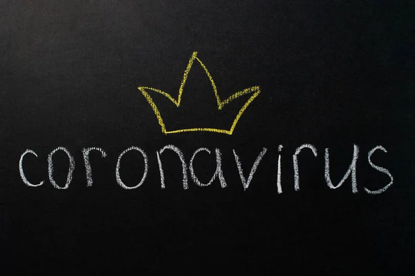 A inscrição "coronavírus" em uma placa preta com giz branco. Desenho de uma coroa amarela. Conceito de epidemia . — Fotografia de Stock