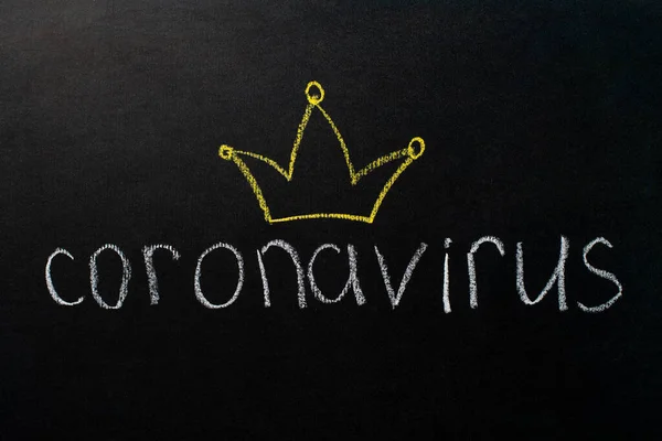 The inscription "coronavirus" on a black board with white chalk. Drawing of a yellow crown. Epidemic concept. — Stock Photo, Image