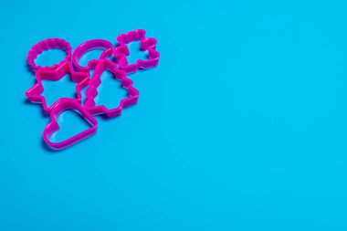 Pembe arka planda kurabiye yapmak için çeşitli şekillerdeki çok renkli plastik kalıplar. Mutfak konsepti. Kopyalama alanı ile düz uzandı.