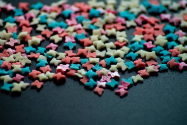 çok renkli şekerleme serpintisi siyah bir arka planda kelebek şeklinde