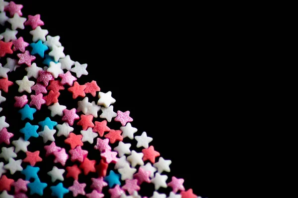 Çok Renkli Şekerleme Serpintisi Siyah Bir Arkaplanda Yıldız Şeklinde Serpiştirir — Stok fotoğraf
