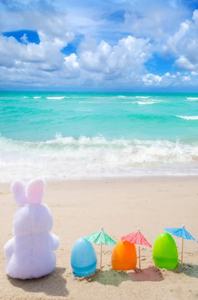 Easter bunny and color eggs on the beach — Stock Photo, Image