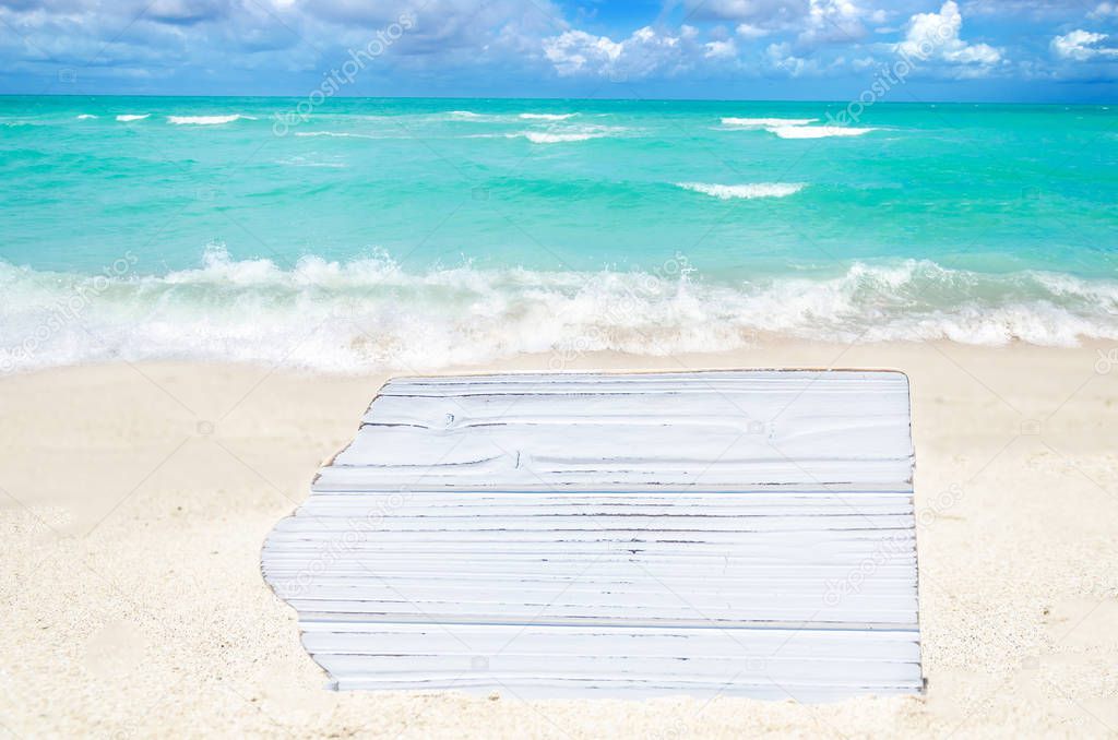 White wood board on the sandy beach