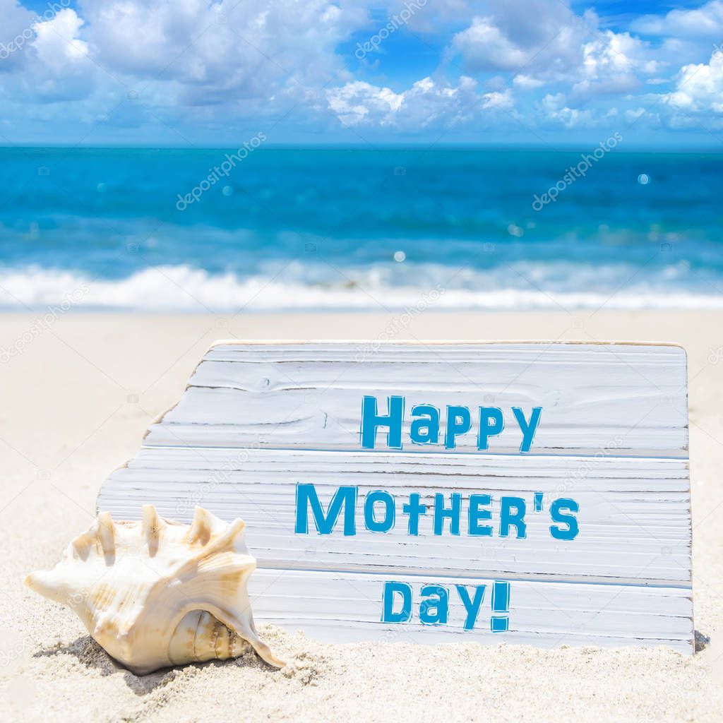 Happy mother's day background with seashell on the sandy beach
