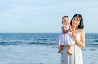 Anne ve bebek kızı kum plajındaki 
