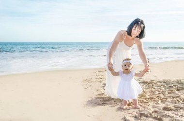 Anne ve bebek kızı kum plajındaki 