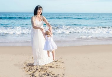 Anne ve bebek kızı kum plajındaki 