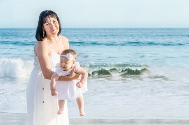 Anne ve bebek kızı kum plajındaki 