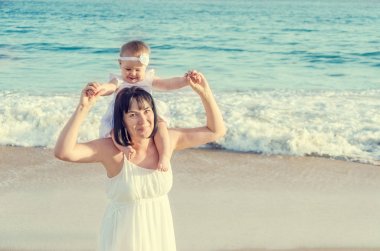 Anne ve bebek kızı birlikte kumlu plajda eğlenmek 