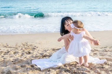Anne ve bebek kızı kum plajındaki 